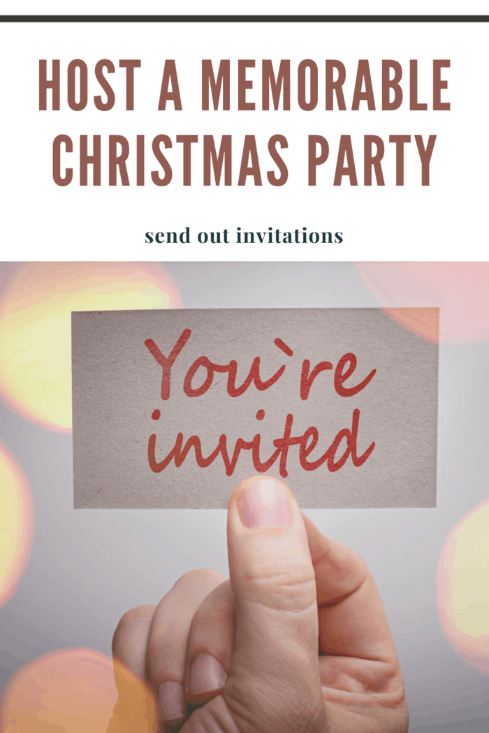 Hand holding a 'You're Invited' card with festive design for a Christmas party