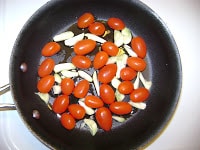 cherry tomatoes and garlic in pan.