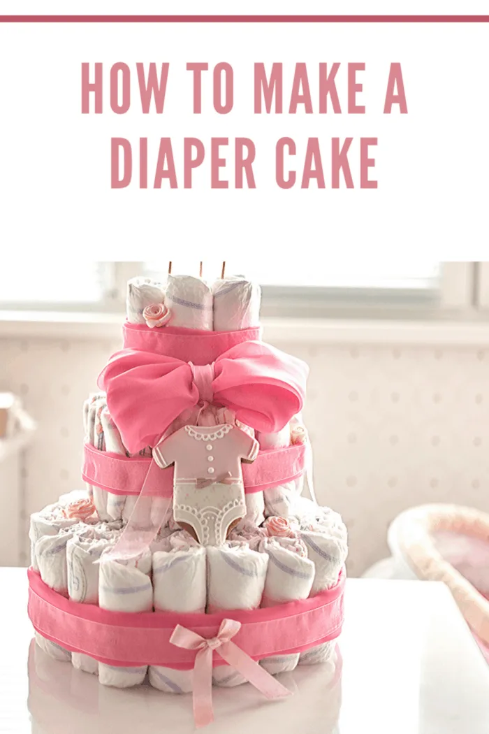 diaper cake with pink ribbon and onsie decorated cookie