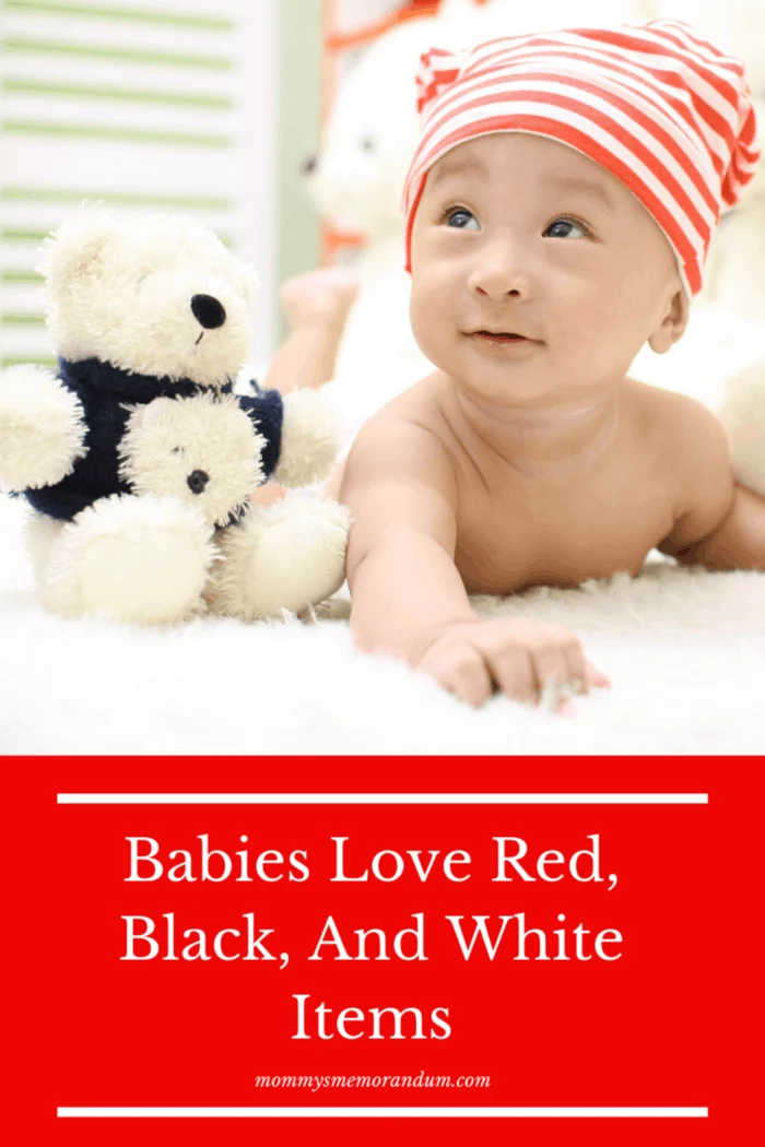 baby with hat next to stuffed animal