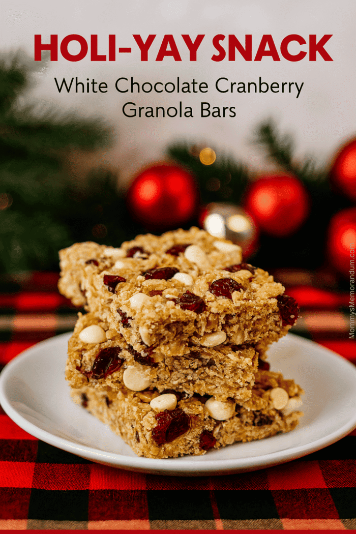 White Chocolate Cranberry Granola Bars – Festive, Easy, and Delicious! Stack of homemade white chocolate cranberry granola bars on a white plate over red buffalo plaid, surrounded by evergreen sprigs and holiday ornaments