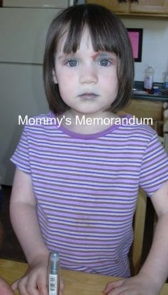 little girl after applying her own makeup