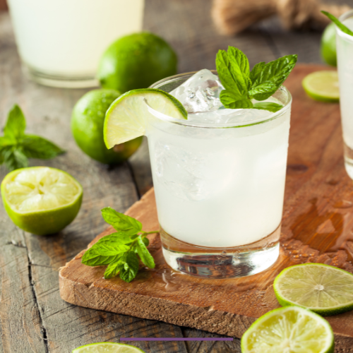 Glasses of mint limeade garnished with fresh mint leaves and lime wedges, a refreshing summer drink.