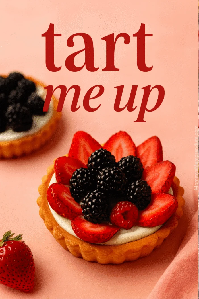 Flat-lay of fruit tart with golden crust, creamy filling, and decorative strawberry and blackberry topping on pink background