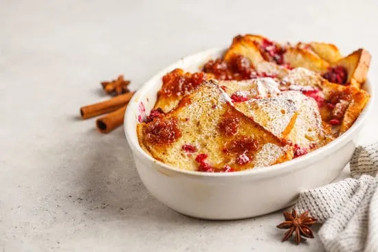 French toast casserole with raspberries, powdered sugar and cinnamon, white background, copy space.