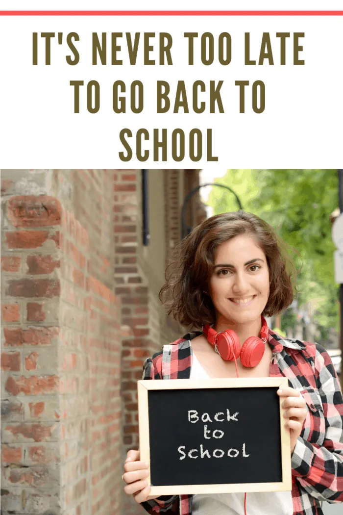 Young beautiful woman holding chalkboard with text 'Back to school'. Education concept. Outdoors.