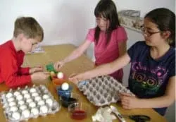 children dipping eggs in dye