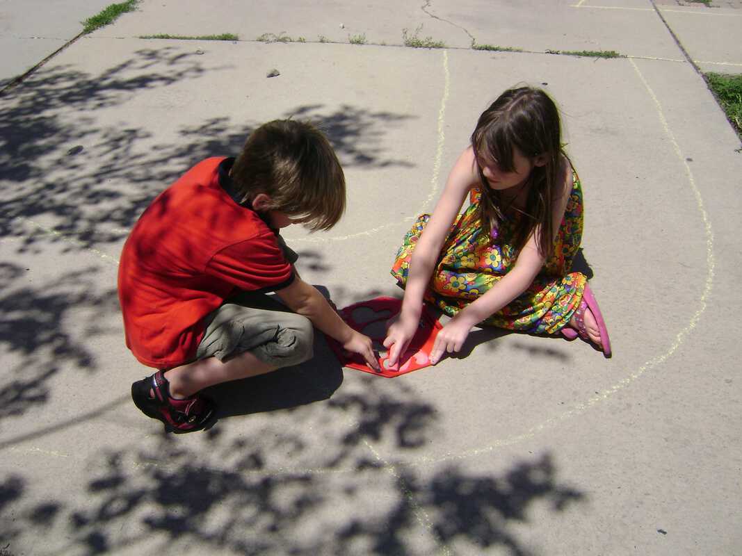 boy and girl using stencil and teamwork for stop sign stencil