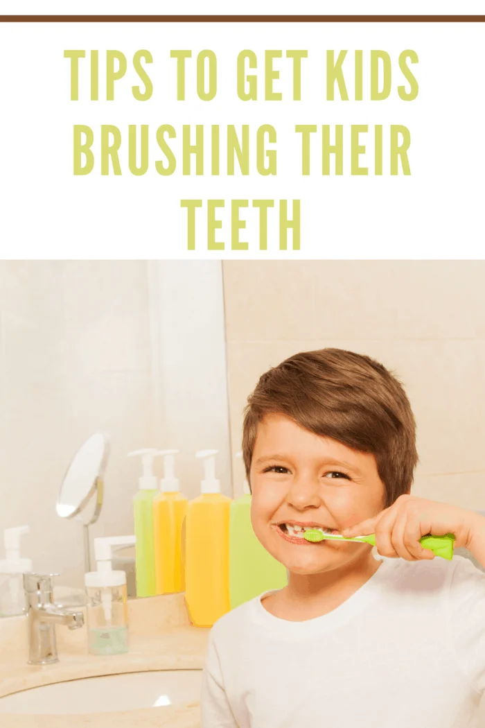 young boy smiling while brushing teeth