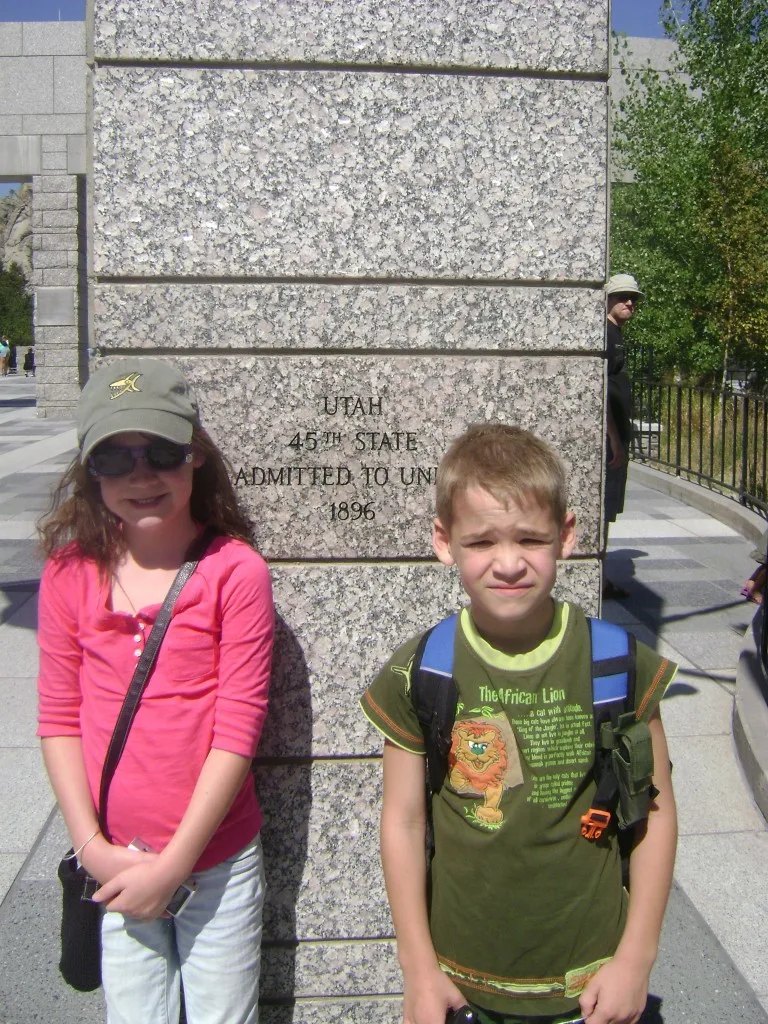 Standing by our home state in the Avenue of Flags below Mount Rushmore