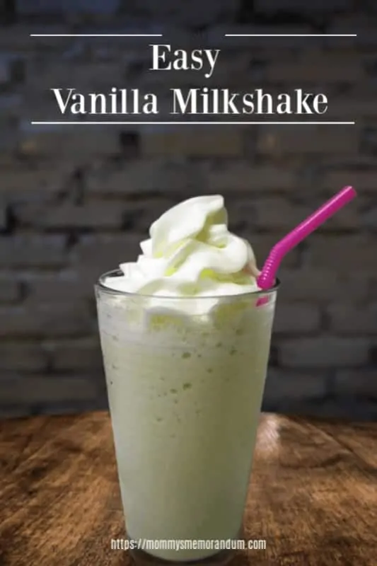 homemade easy vanilla milkshake on wood table with pink straw and brick background