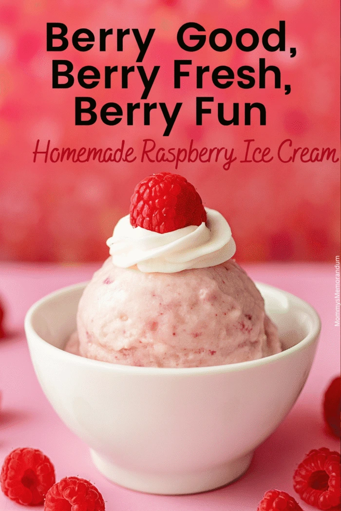 A scoop of pale pink raspberry ice cream with raspberry flecks, served in a white bowl, topped with whipped cream and a fresh raspberry.