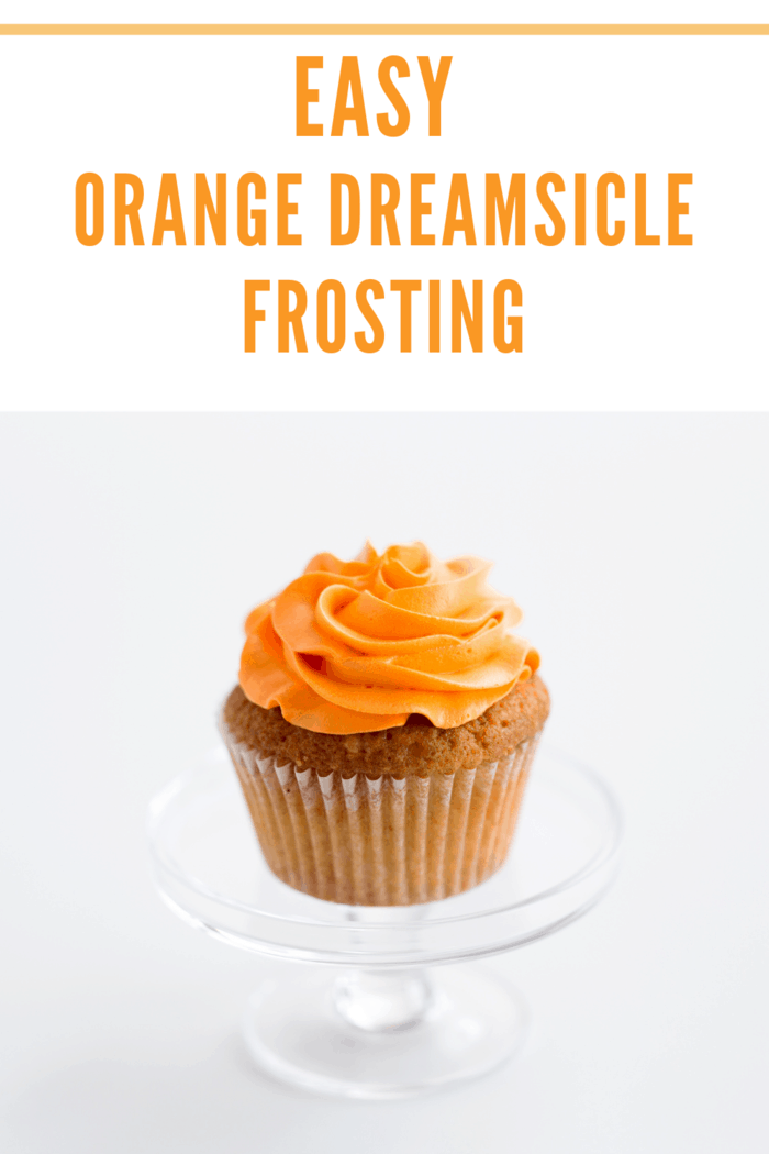 A single cupcake with beautifully piped orange dreamsicle buttercream frosting on top.