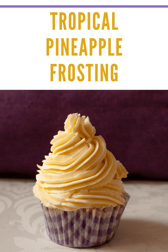 Cupcake topped with tropical pineapple frosting in a purple checkered wrapper