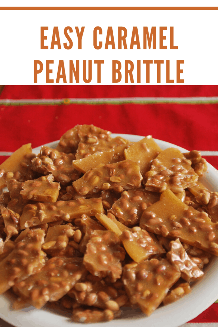 easy caramel peanut brittle broken up on white plate with red background