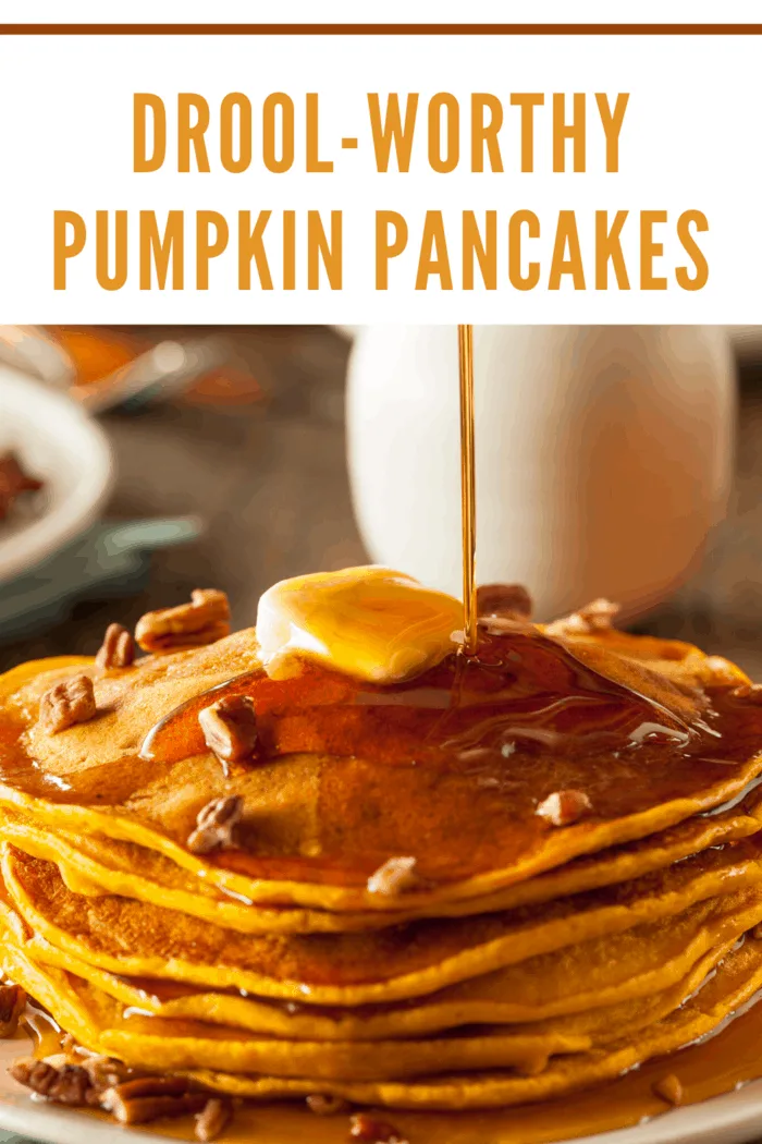 Pumpkin pancake s stacked and topped with butter and drizzling with maple syrup.
