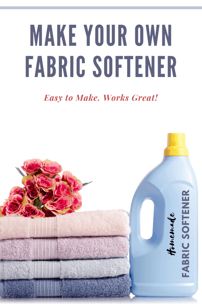 A bottle of homemade fabric softener next to a stack of pastel-colored towels and pink roses.