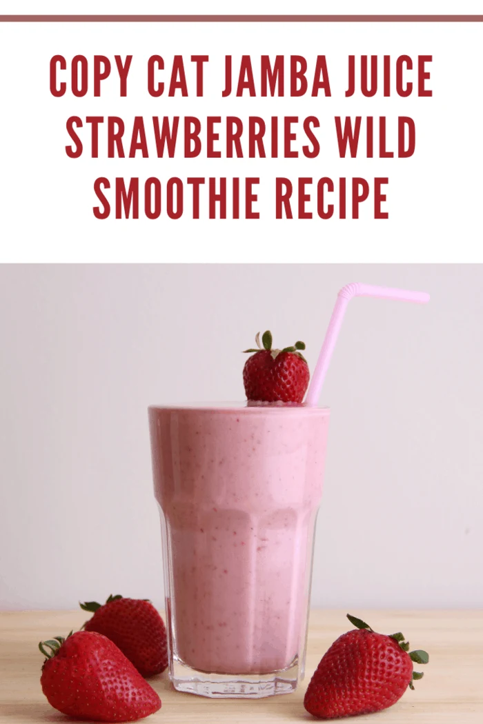 Copycat Jamba Juice Strawberries Wild Smoothie in a glass with fresh strawberries and a straw