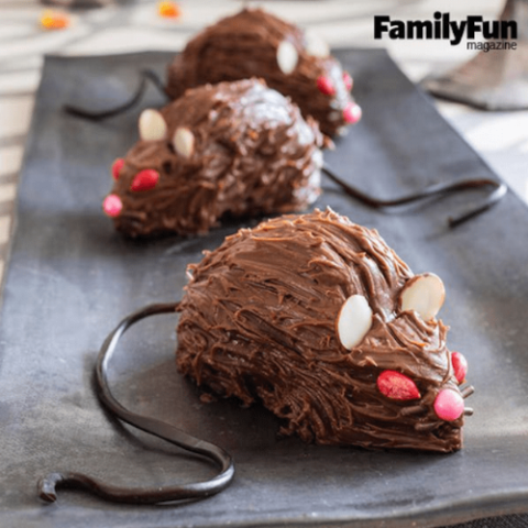 Halloween chocolate donut rats with licorice tails, almond ears, and candy eyes for a fun and creepy party snack