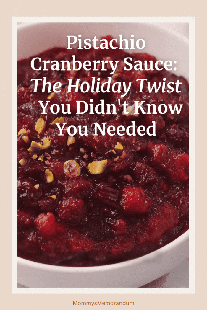 Bowl of pistachio cranberry sauce topped with chopped pistachios and lemon zest, styled with warm holiday decor
