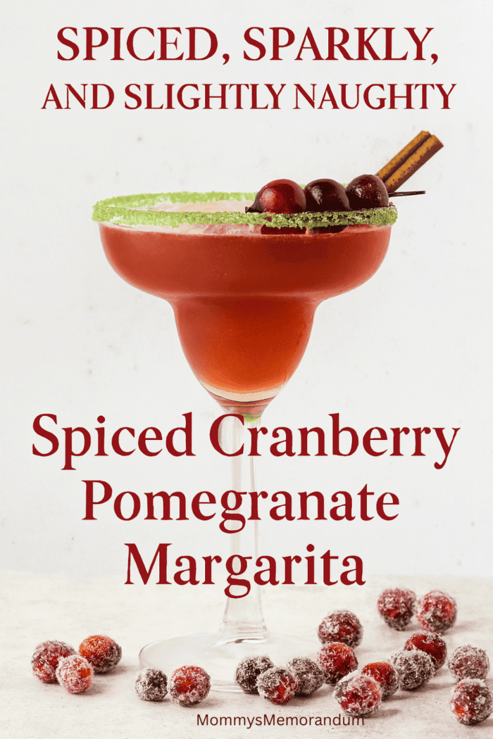 A festive margarita in a sugar-rimmed glass garnished with cranberries and a cinnamon stick, surrounded by sugared cranberries. Text overlay reads 'Spiced, Sparkly, and Slightly Naughty' with subtitle 'Spiced Cranberry Pomegranate Margarita.' Holiday-themed cocktail image with warm lighting and cozy seasonal vibes.