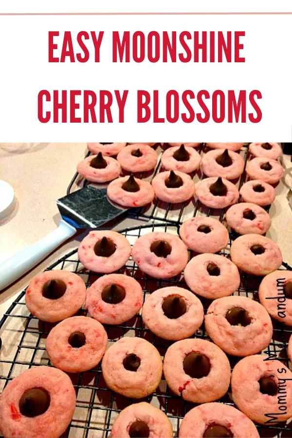 Moonshine Cherry Blossoms cookies topped with Hershey's Kisses, featuring a sweet, boozy twist.