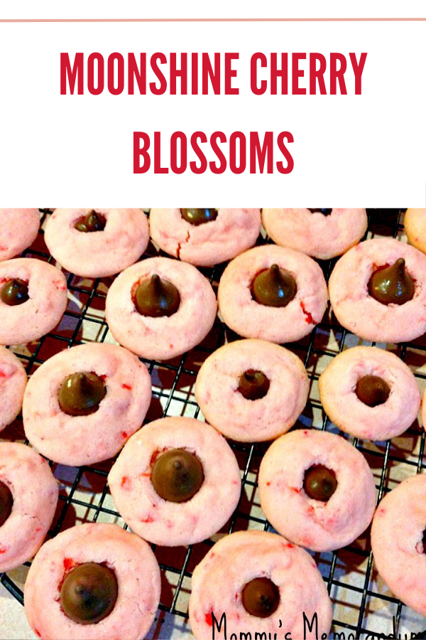 Moonshine Cherry Blossoms cookies topped with Hershey's Kisses, featuring a sweet, boozy twist.