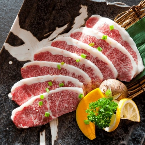 Wagyu Beef sliced decorated in a plate on table