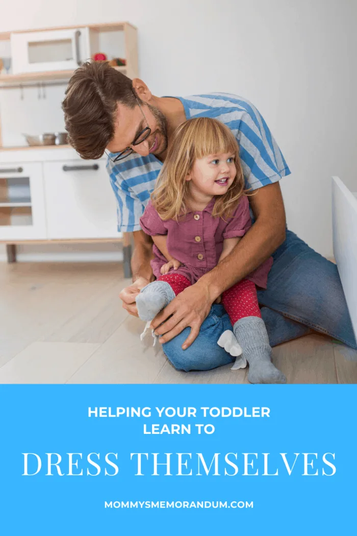 father and daughter working together to teach toddler how to dress theselves