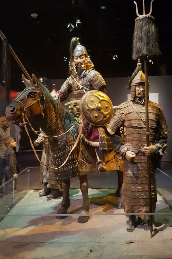 Historical chainmail, helmets, chairs, and swords from the Mongol era, showcasing detailed craftsmanship.