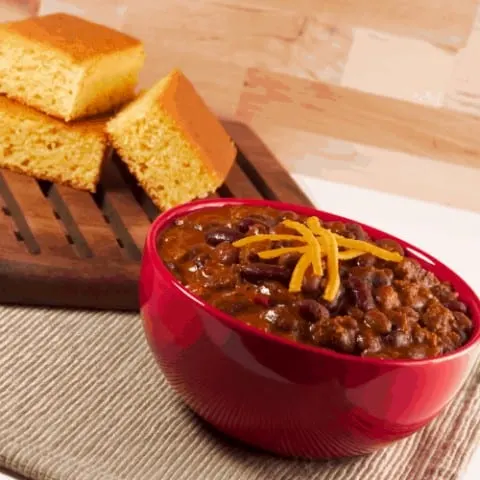 Classic combination of spicy chili with beans and homemade cornbread. Shallow DOF.