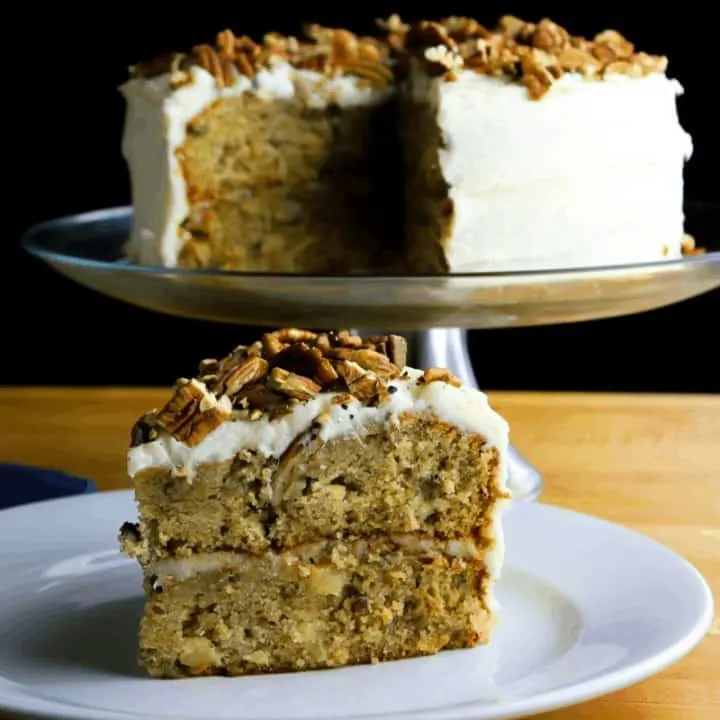 A slice of homemade two-layered hummingbird cake with a cup of coffee