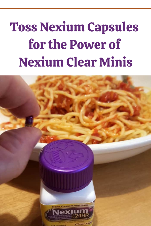 Nexium Clear Mini held between fingers with Italian food in the background, showcasing heartburn relief.