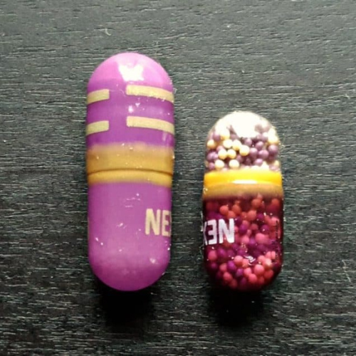 Nexium Clear Mini next to a regular Nexium capsule, highlighting the size difference for heartburn relief.