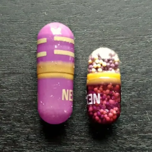 Nexium Clear Mini next to a regular Nexium capsule, highlighting the size difference for heartburn relief.