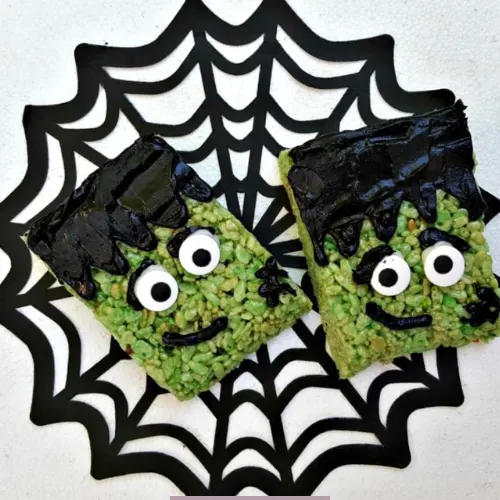 Green Frankenstein Rice Krispies Treats decorated with candy eyes and dark chocolate frosting for Halloween.