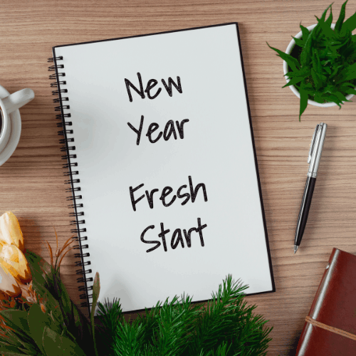 Notepad with wish list and coffee cup. New year's hope and resolution concept - New Year, Fresh Start.