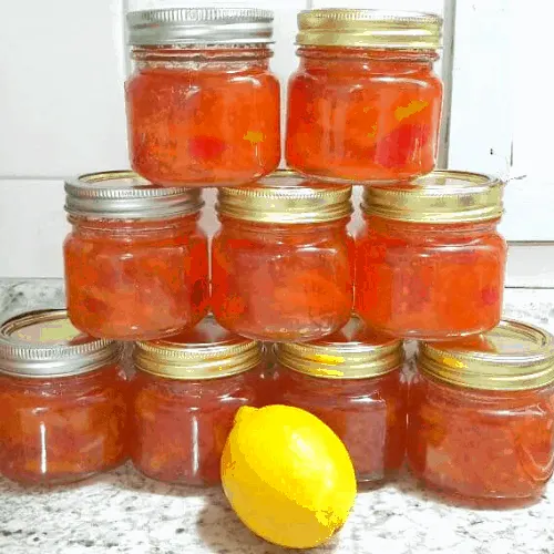 homemade instant pot lemon cherry marmalade in jars stacked in pyramid shape with lemon in front.