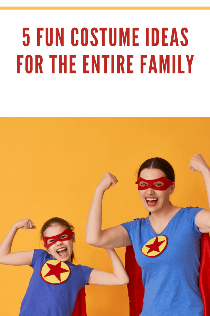 Mother and her child playing together. Girl and mom in Superhero costumes. Mum and kid having fun and smiling. Family holiday and togetherness.