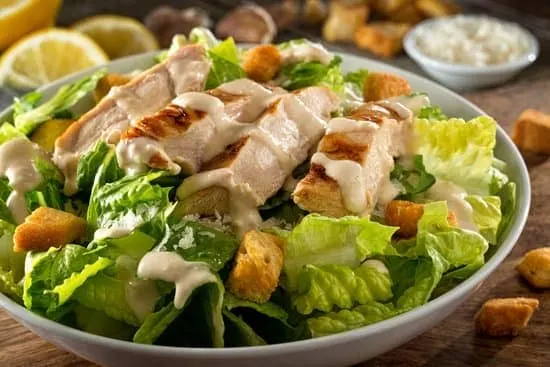 close up of chicken caesar salad in bowl