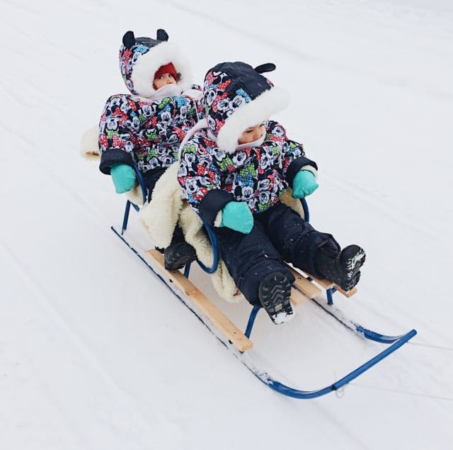 little girls on sled going down hill
