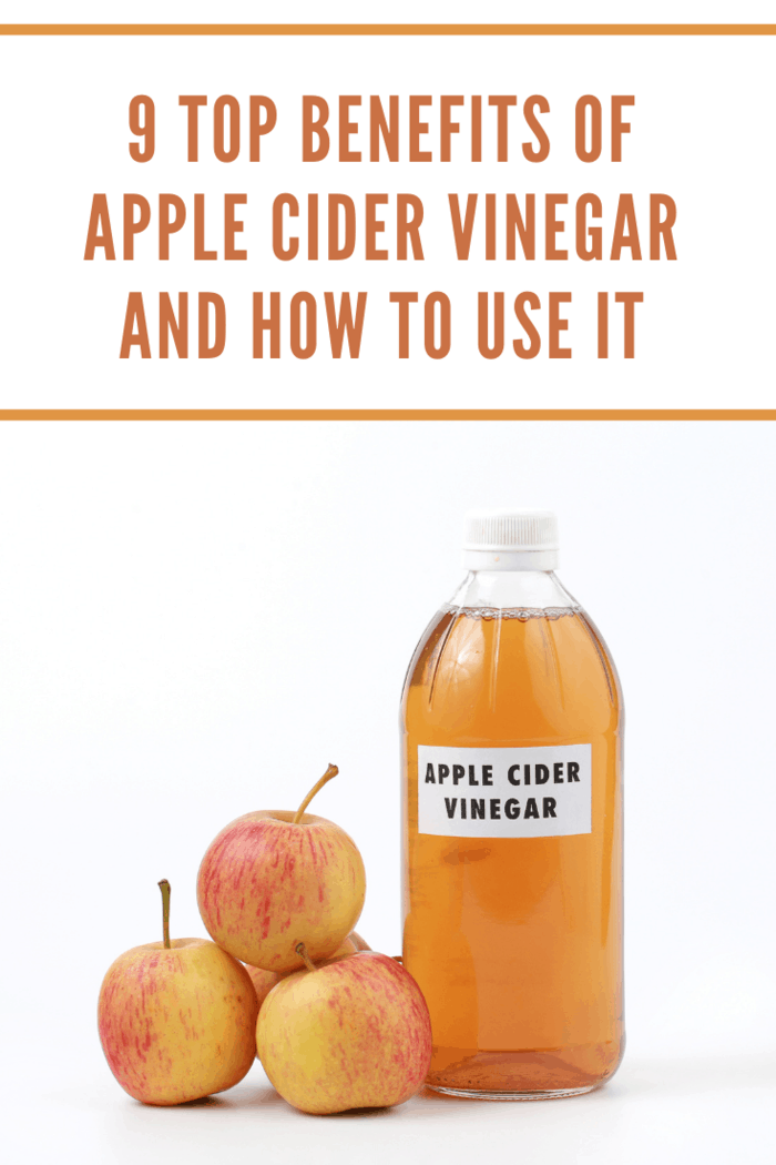 Apple cider vinegar in a bottle with red apples on white background