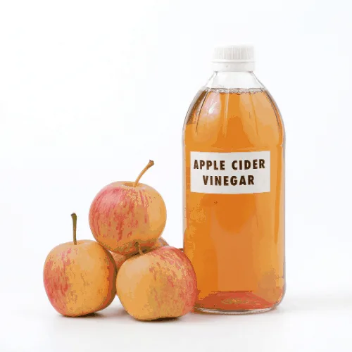 Apple cider vinegar in a bottle with red apples on white background