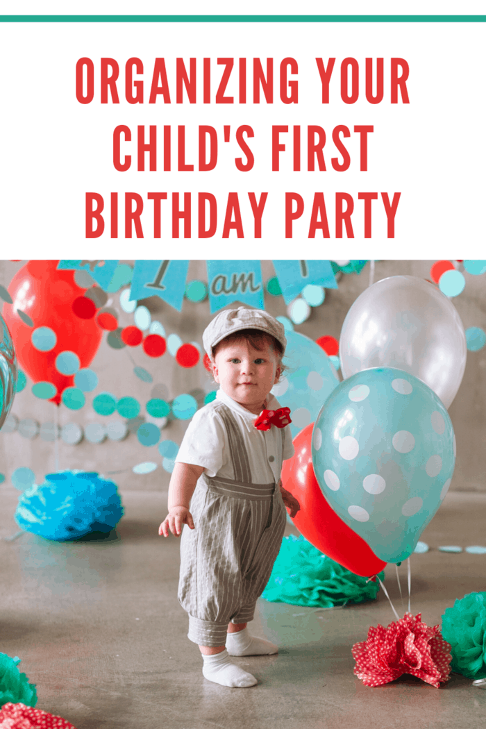 Festive background decoration for birthday celebration with boy in crown and teal, red and blue decorations and balloons in background