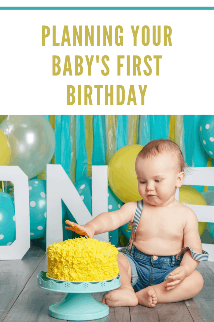 planning your baby's first birthday party with a teal and yellow color theme baby boy in overalls with hand in yellow iced cake