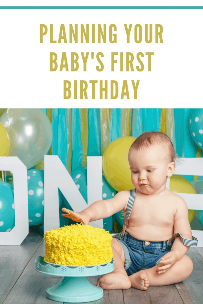 planning your baby's first birthday party with a teal and yellow color theme baby boy in overalls with hand in yellow iced cake