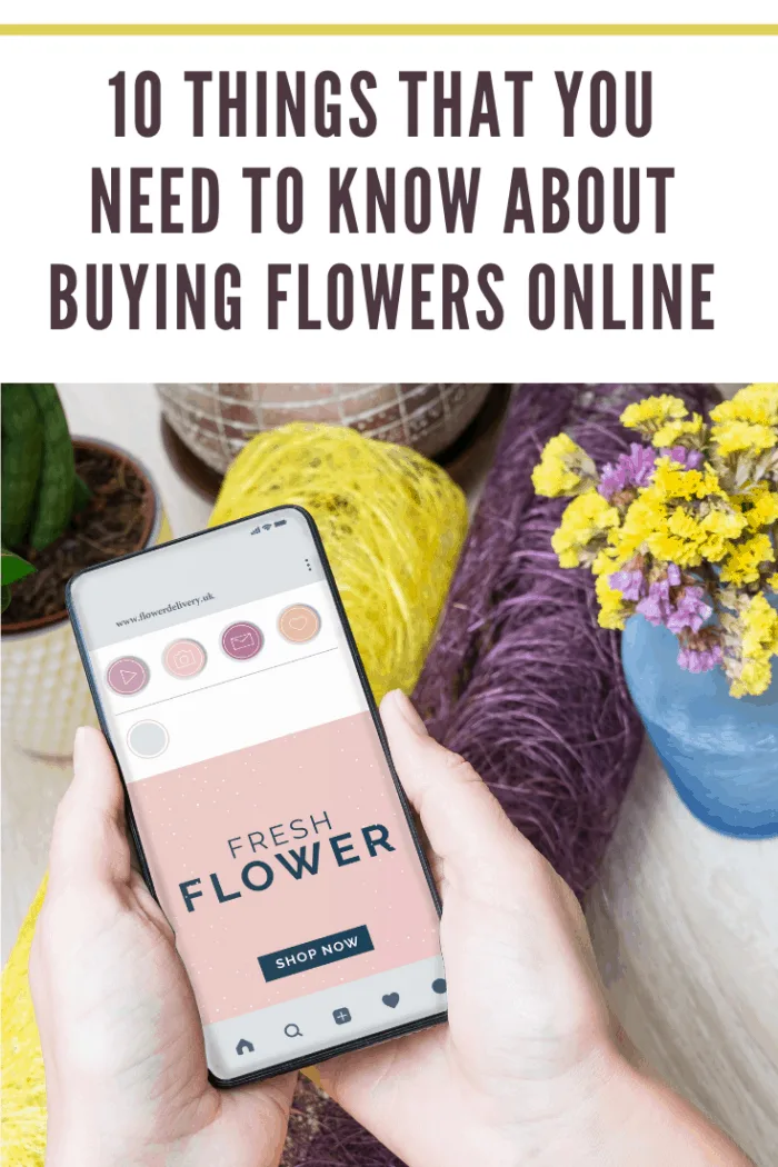 Mobile phone displaying an online flower delivery website surrounded by fresh yellow and purple flowers
