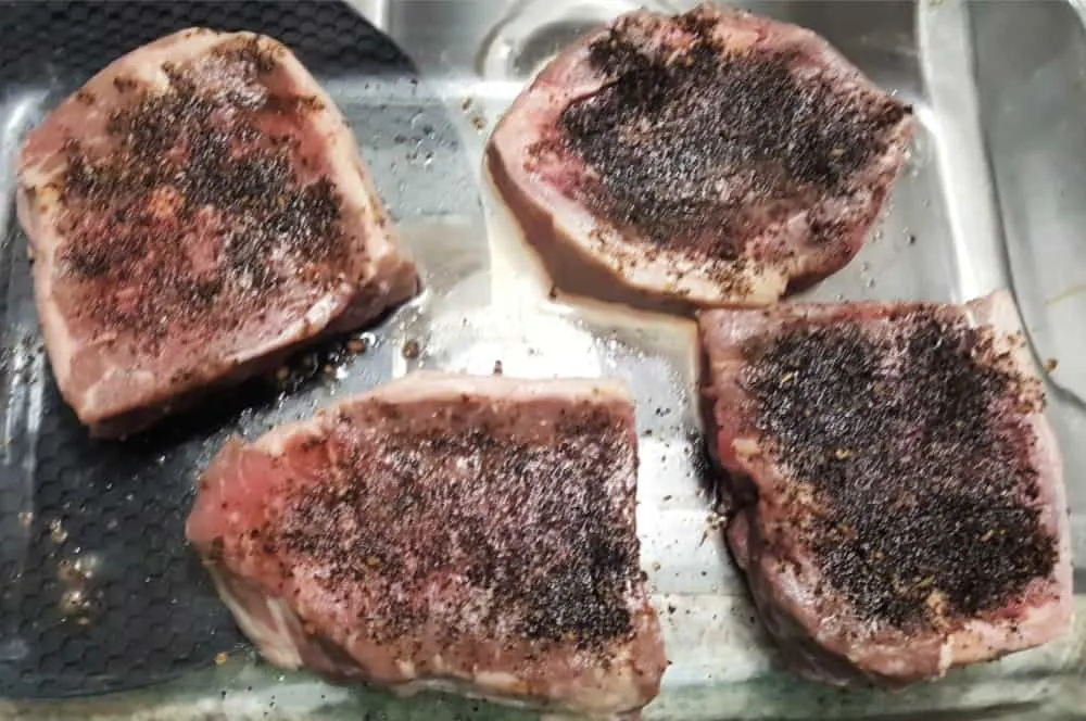 ribeye steaks with coffee rub on them resting