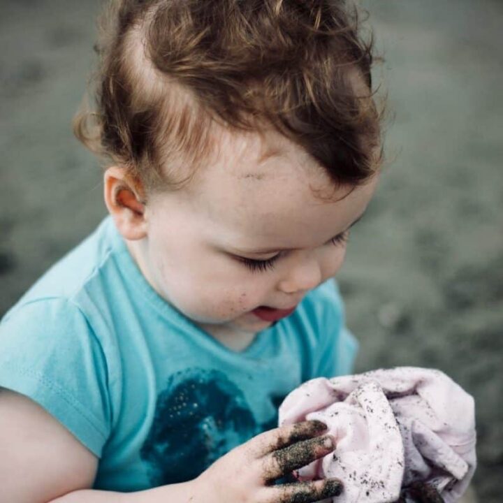baby playing in sand
