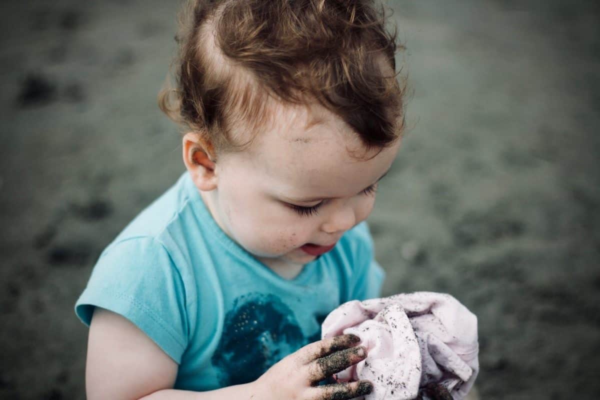 baby playing in sand while staying in a baby friendly rental